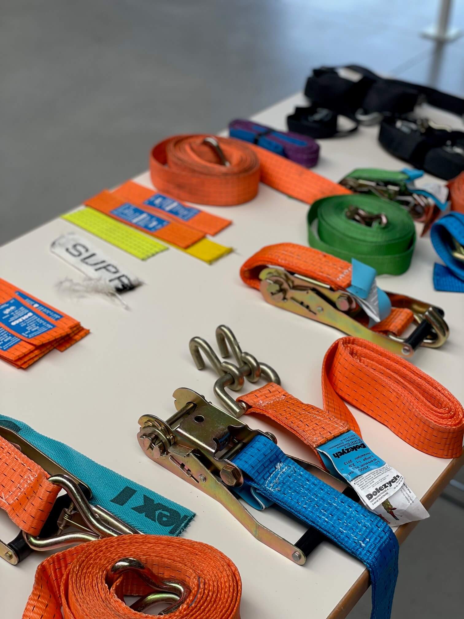 Mehrere Arbeiter mit gelben Warnwesten bedienen Gabelstapler und rote Teleskoplader, bewegen Holzpaletten vor Industriehalle.