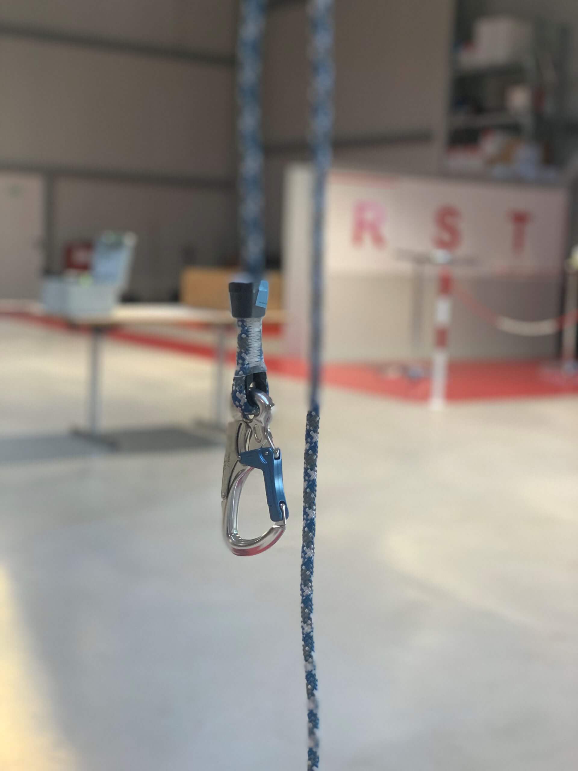 Mehrere Arbeiter mit gelben Warnwesten bedienen Gabelstapler und rote Teleskoplader, bewegen Holzpaletten vor Industriehalle.