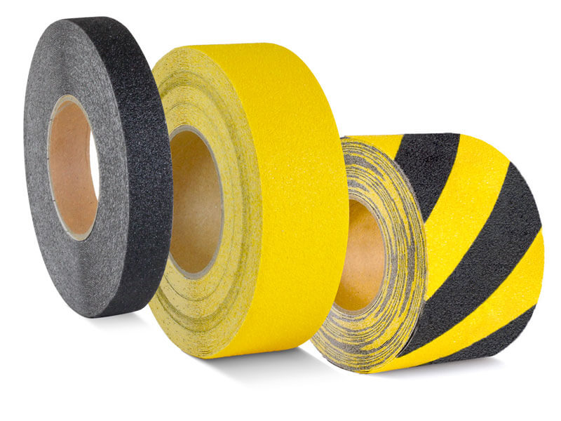 Three rolls of tape: dark gray/black, solid yellow, and yellow with black hazard stripes (hazard tape).