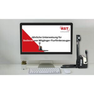 Monitor displaying a poster with red diagonal design, RST Ausbildungsakademie logo, and German safety training title about annual instructions for forklift and pedestrian-powered equipment operators on a clean desk