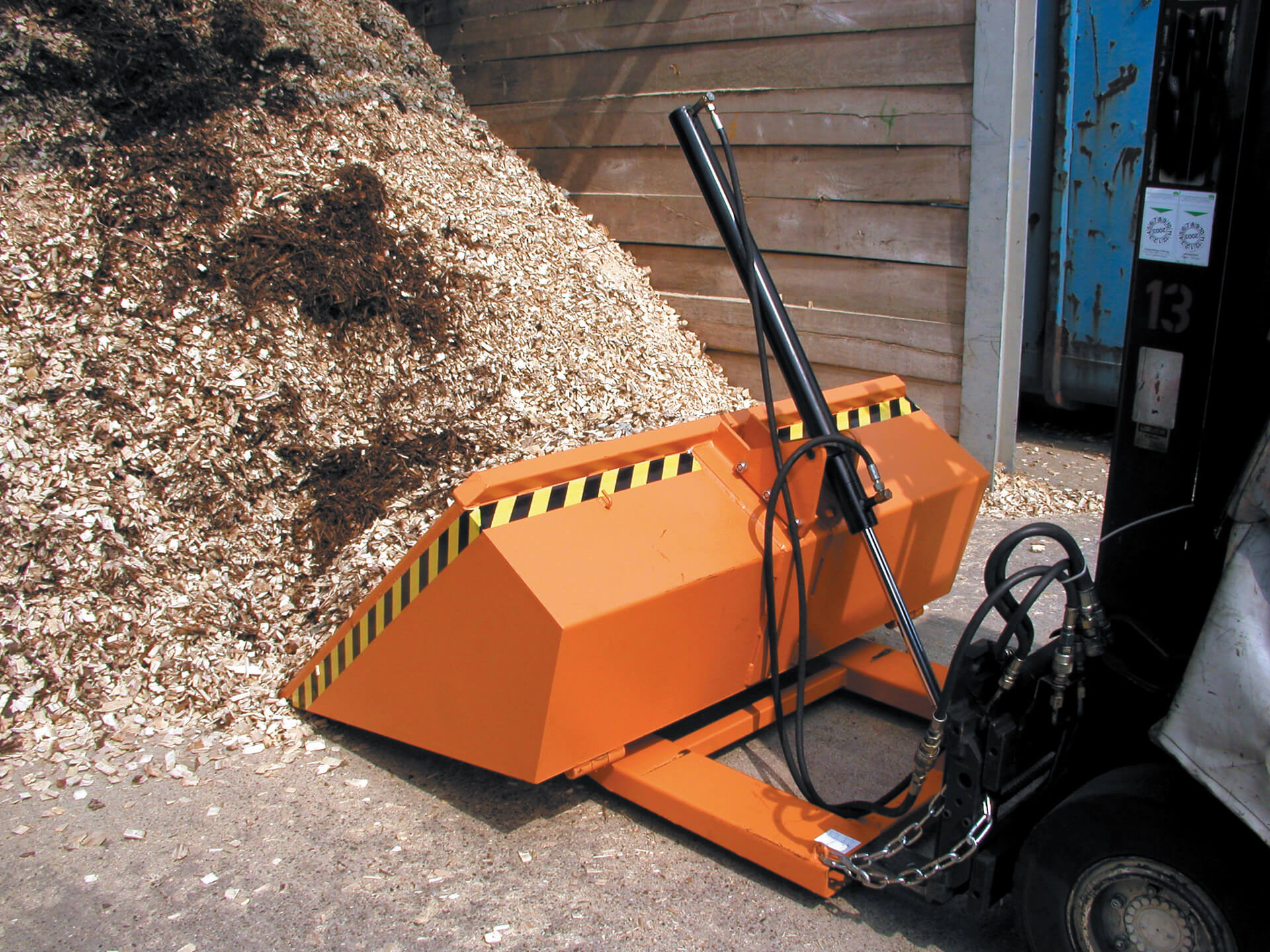 Gelb-schwarze Unterfahrschutz-Balken im Lager, montiert vor Metallregalen mit gestapelten Lagerbehältern.